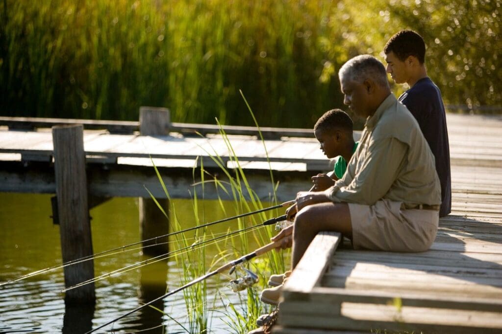A man and his son are fishing on a dock.