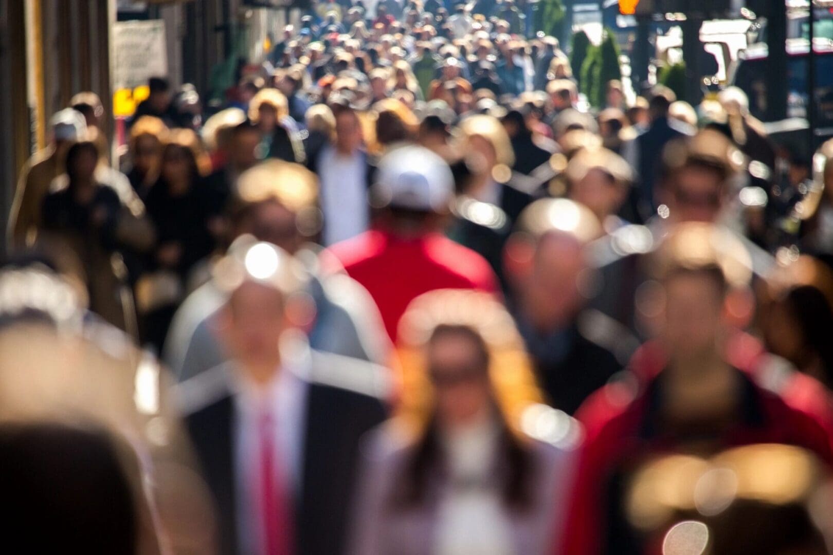 A blurry image of a crowd of people walking down a street.