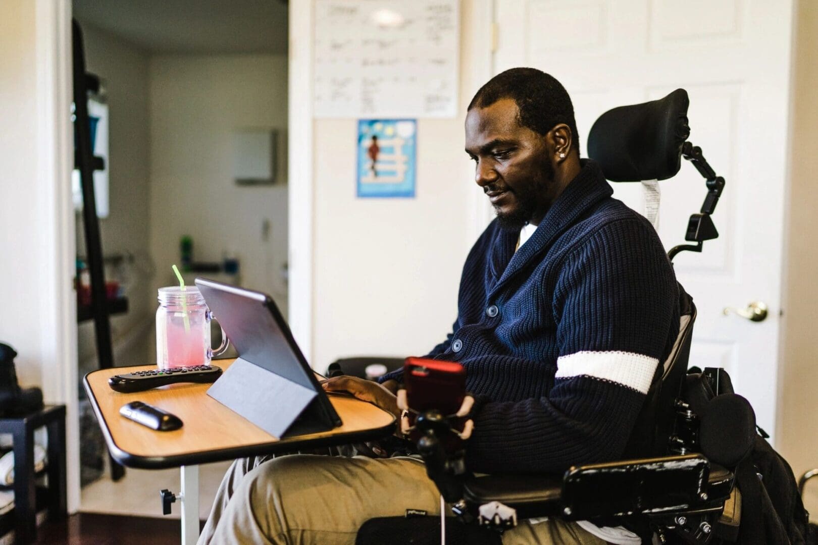 A man in a wheelchair using a laptop.