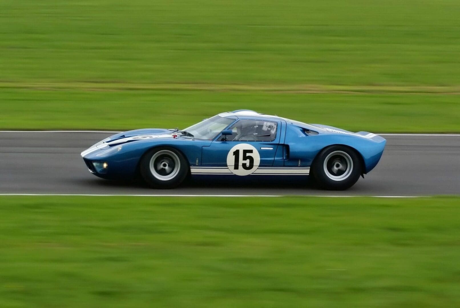 A blue race car driving down a track.