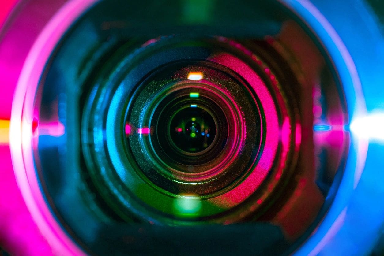 A close up of a camera lens with colorful lights.