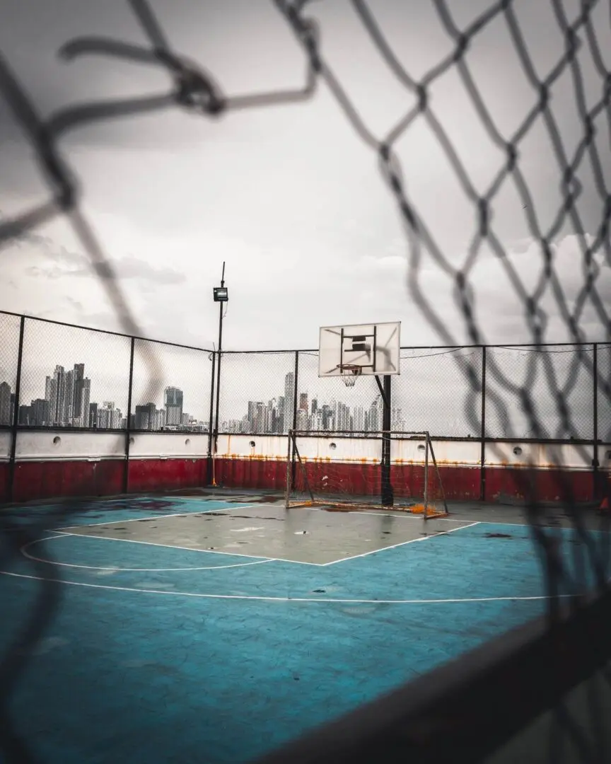 A basketball court with a fence in the background.