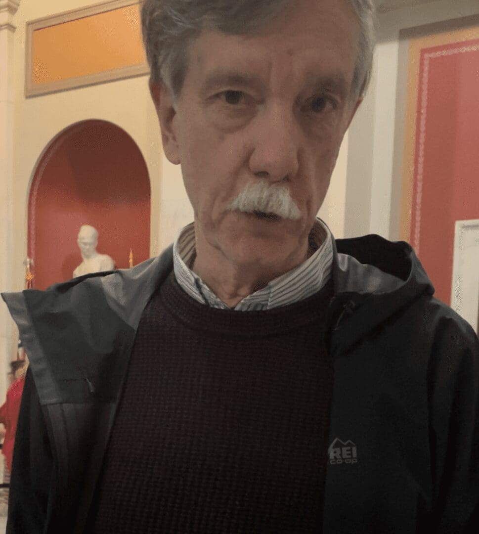 A man with a mustache in a museum.