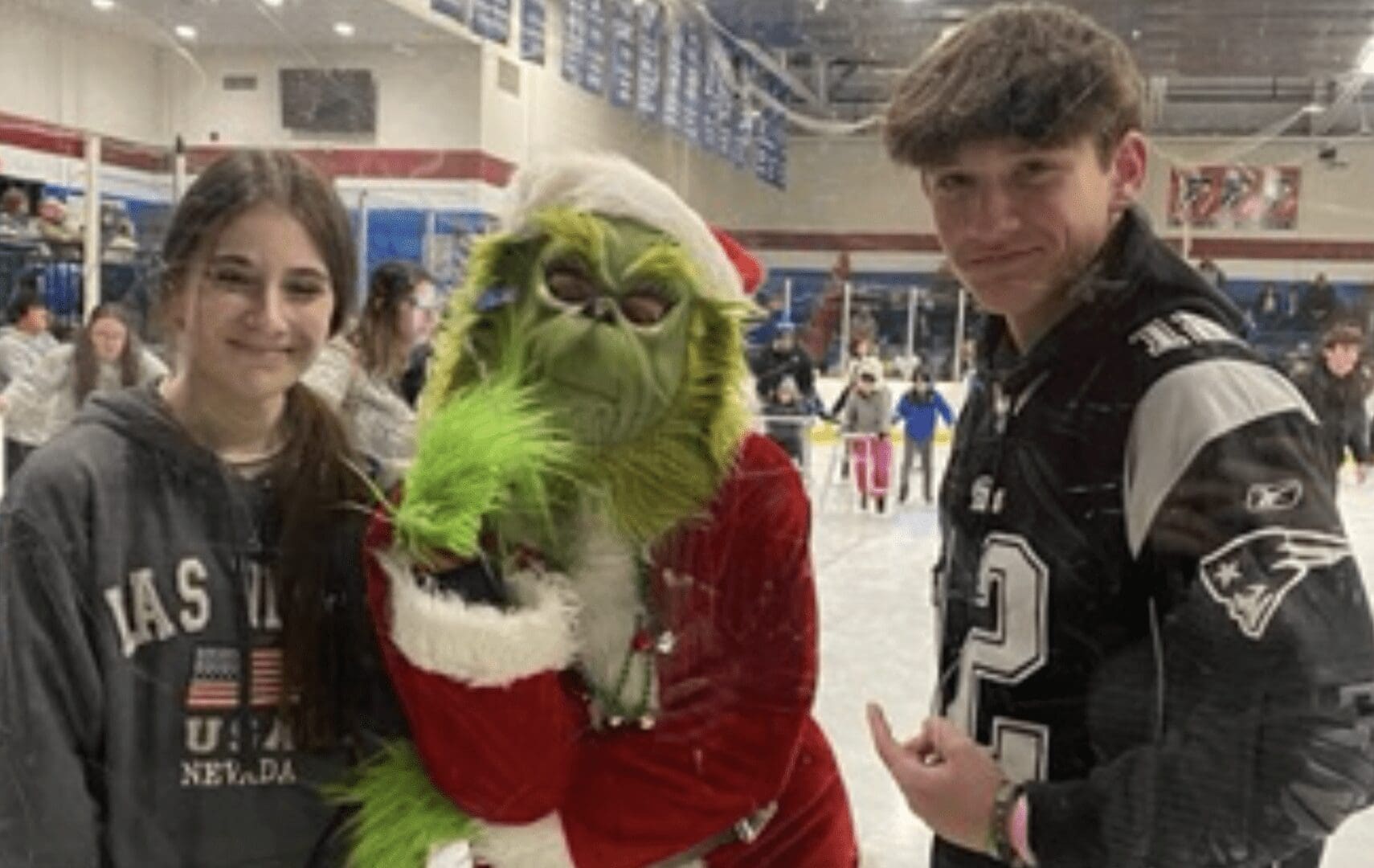 A group of people posing with a santa claus mascot.