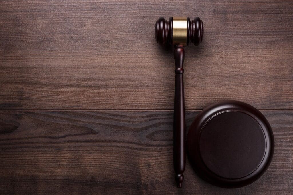 A wooden gavel on top of a wooden table.