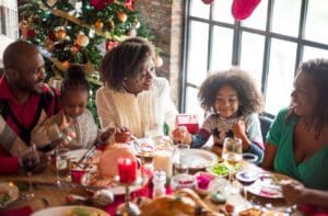 A family sits at a table and eats a christmas dinner.