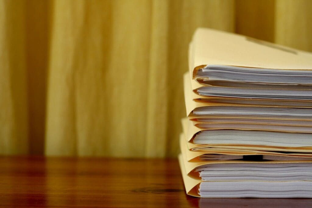 A stack of papers on a wooden table.