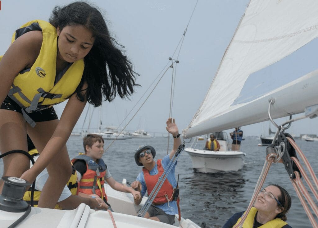 A group of young people on a sailboat.