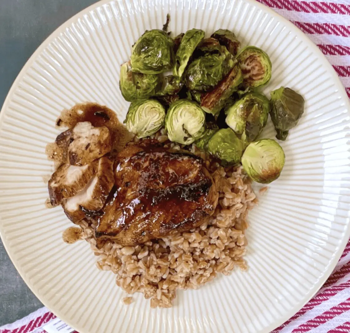 A plate with chicken, brussels sprouts and rice.