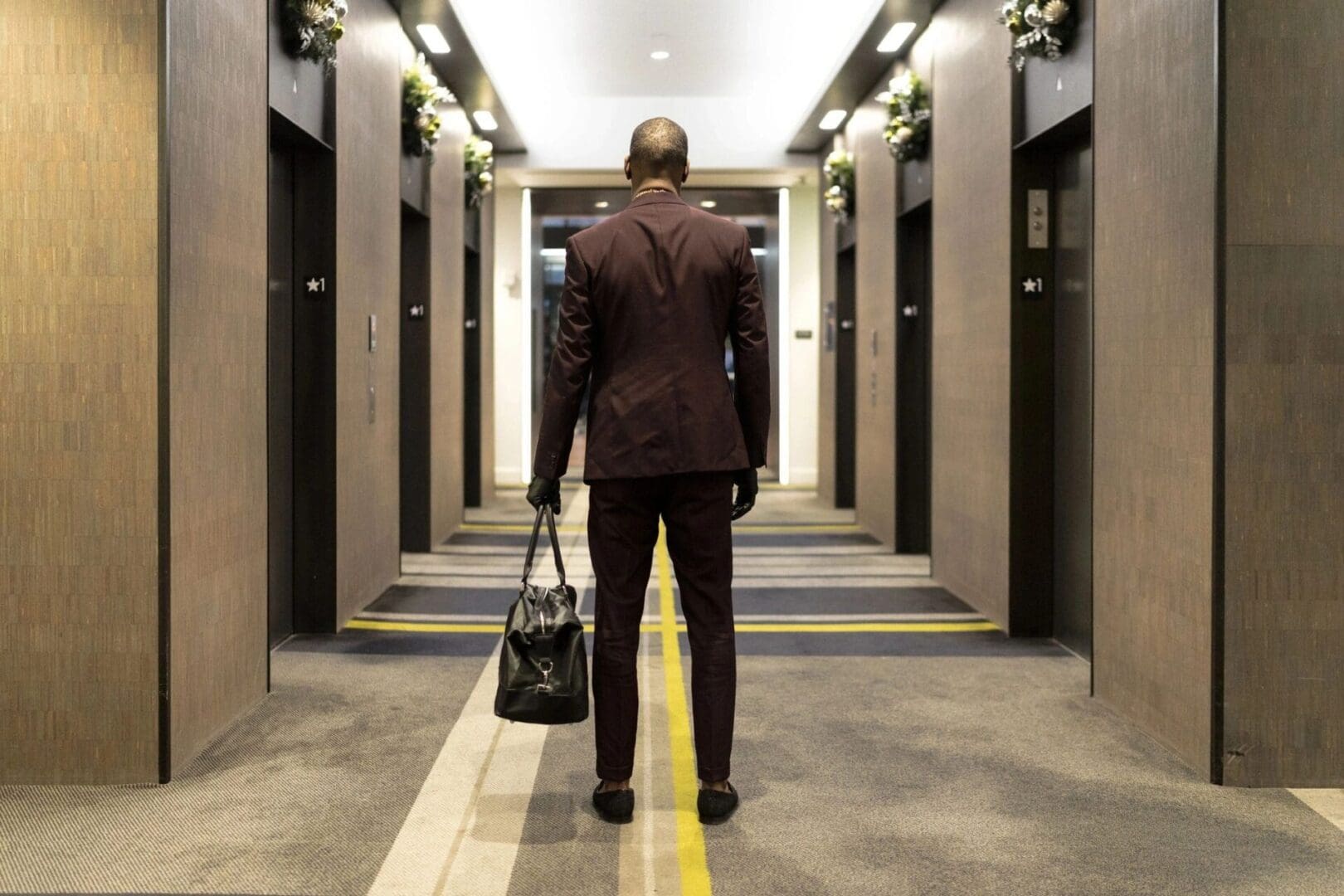 A man in a suit walking down an elevator.