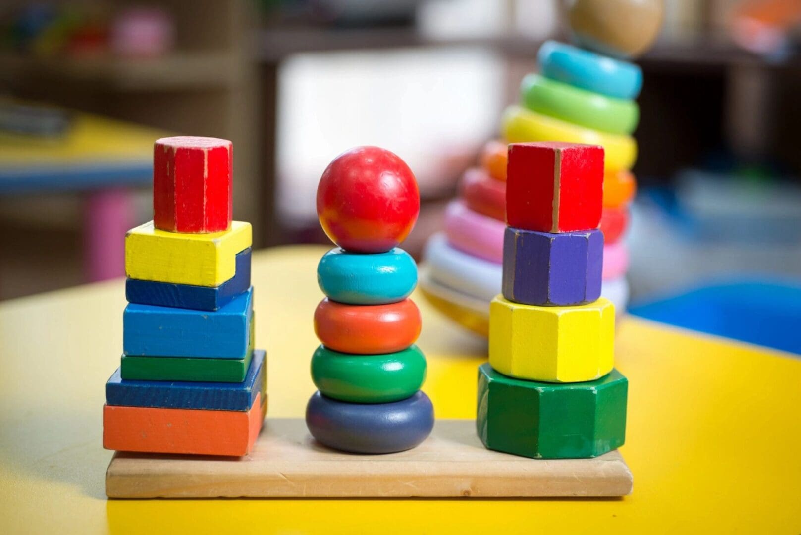 A stack of colorful blocks on a table in a child's playroom.
