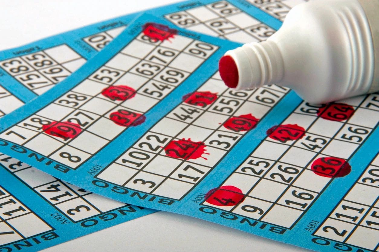 A bottle of water and bingo cards on a table.