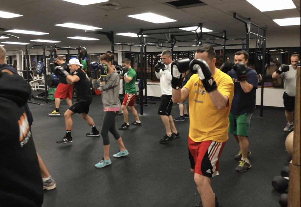 A group of people practicing boxing in a gym.
