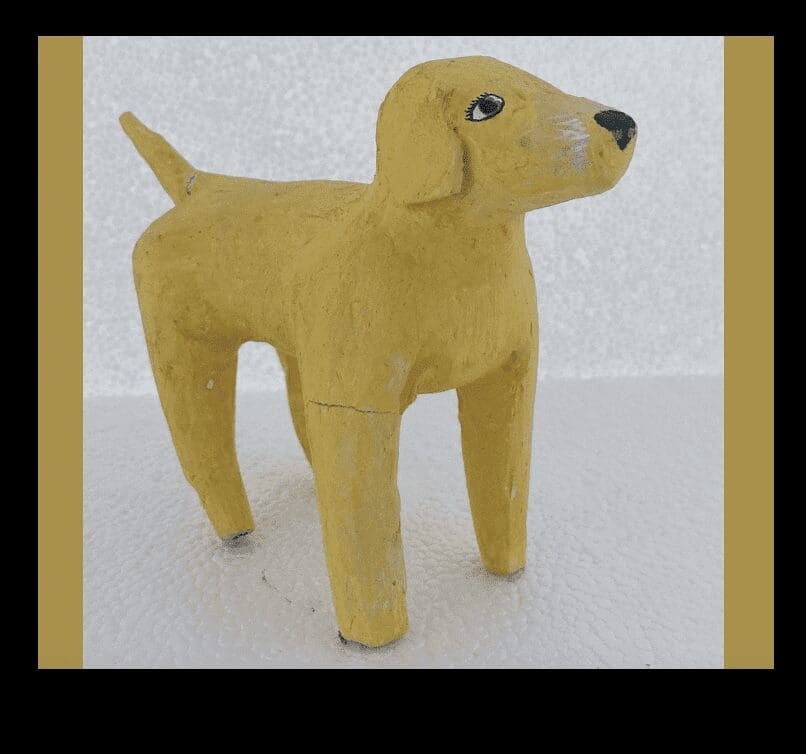 A yellow wooden dog standing on a white surface.