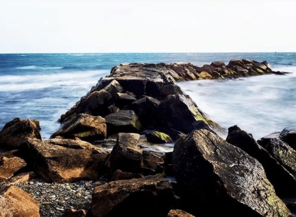 A rocky shore with waves crashing over rocks.