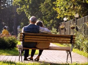 A couple sitting on a bench in a park.