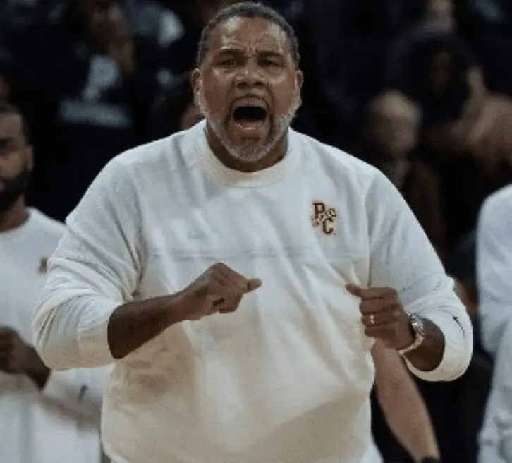 A basketball coach yelling at his team on the court.