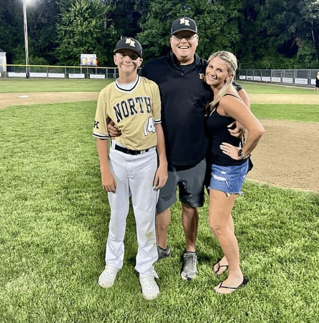 A family posing for a picture on a baseball field.