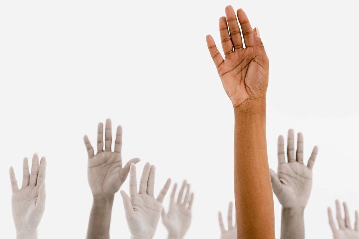 A group of people raising their hands in the air.