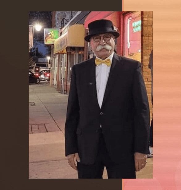 A man in a tuxedo standing on a sidewalk outside the DaVinci Center.