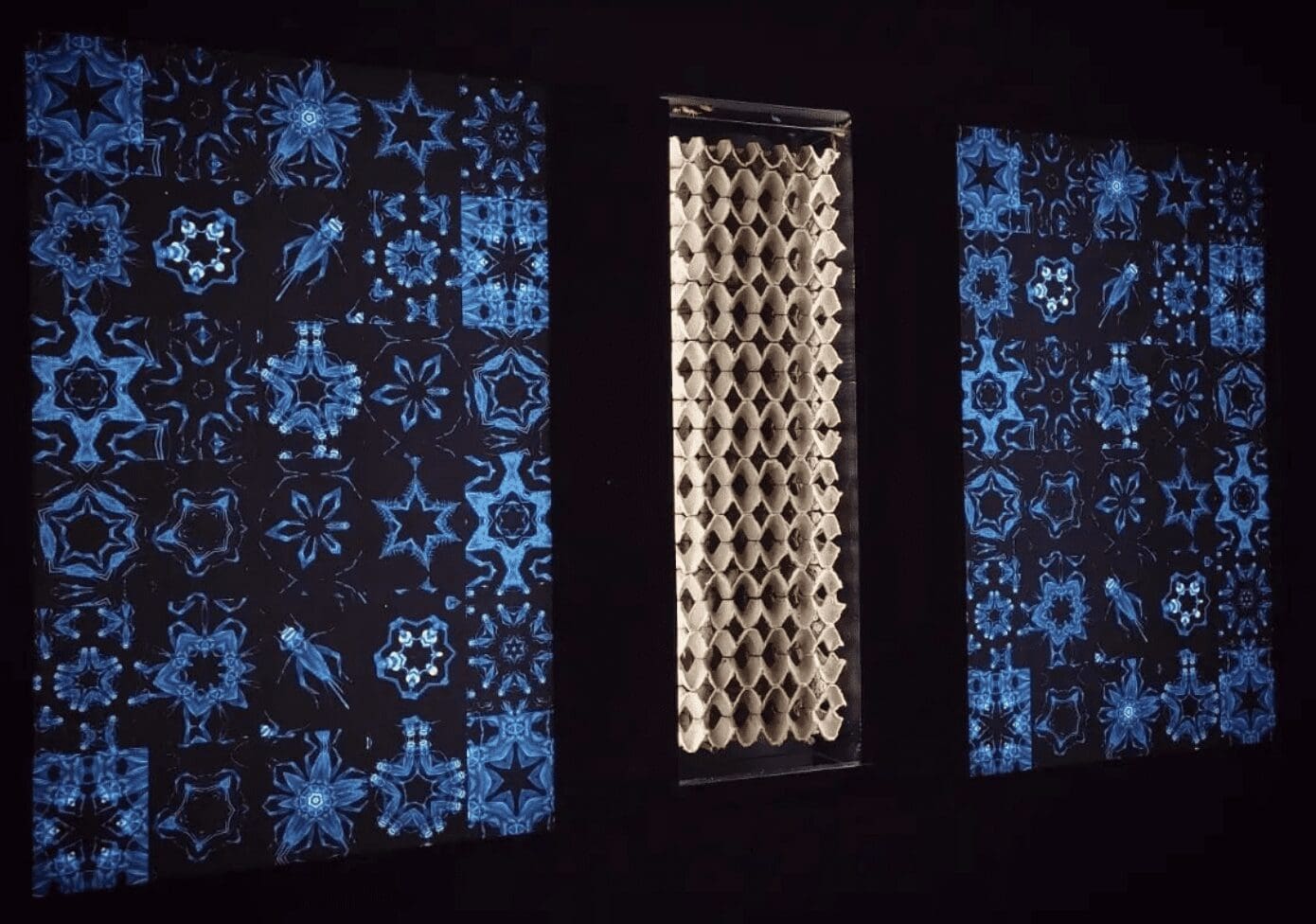 Three art panels in a dark room.