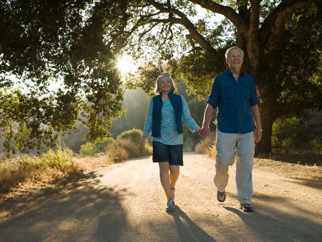 An older couple walking down a dirt road.