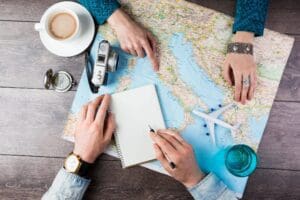 Two people looking at a map with a cup of coffee.
