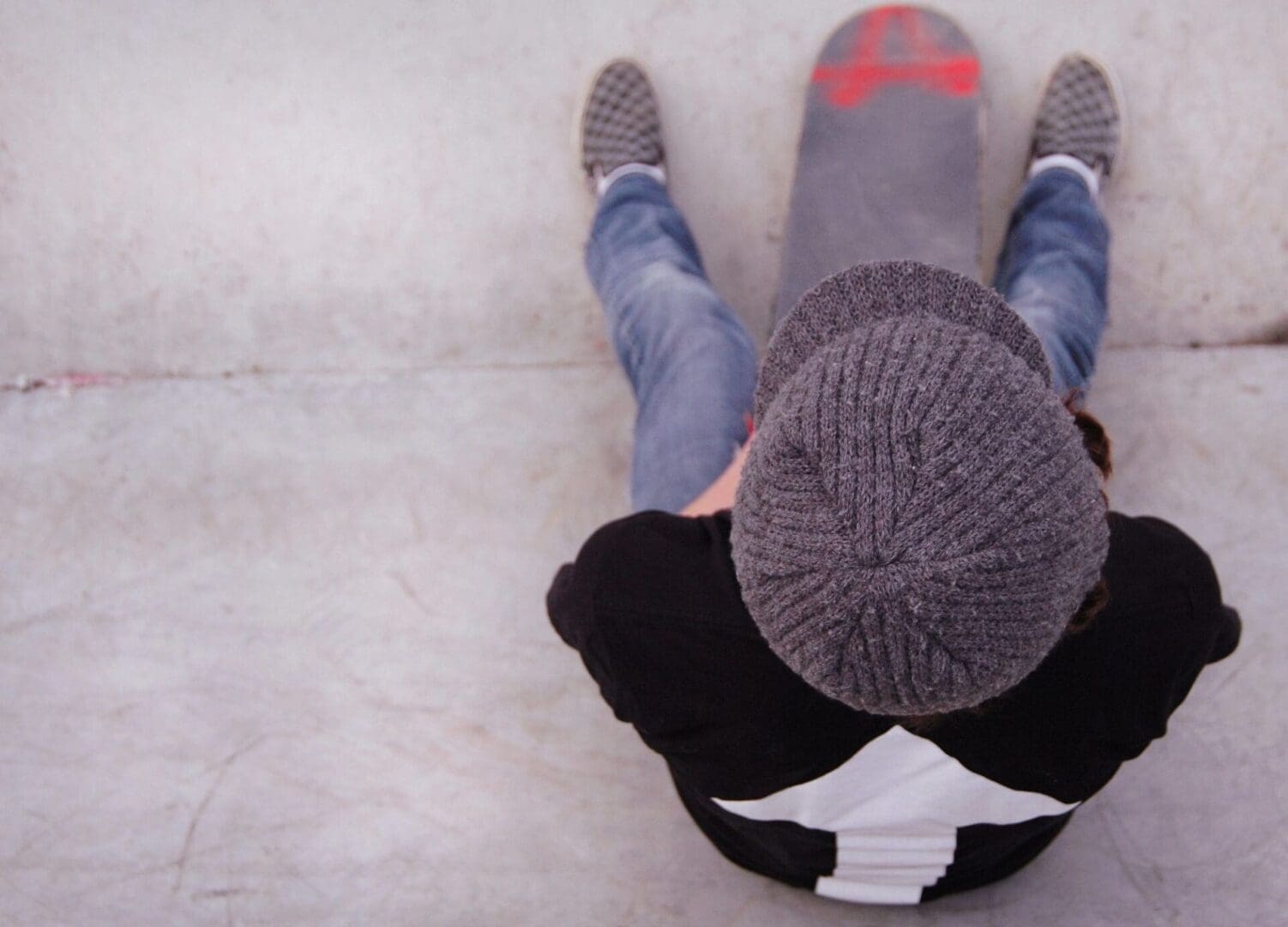 A person sitting on a skateboard.