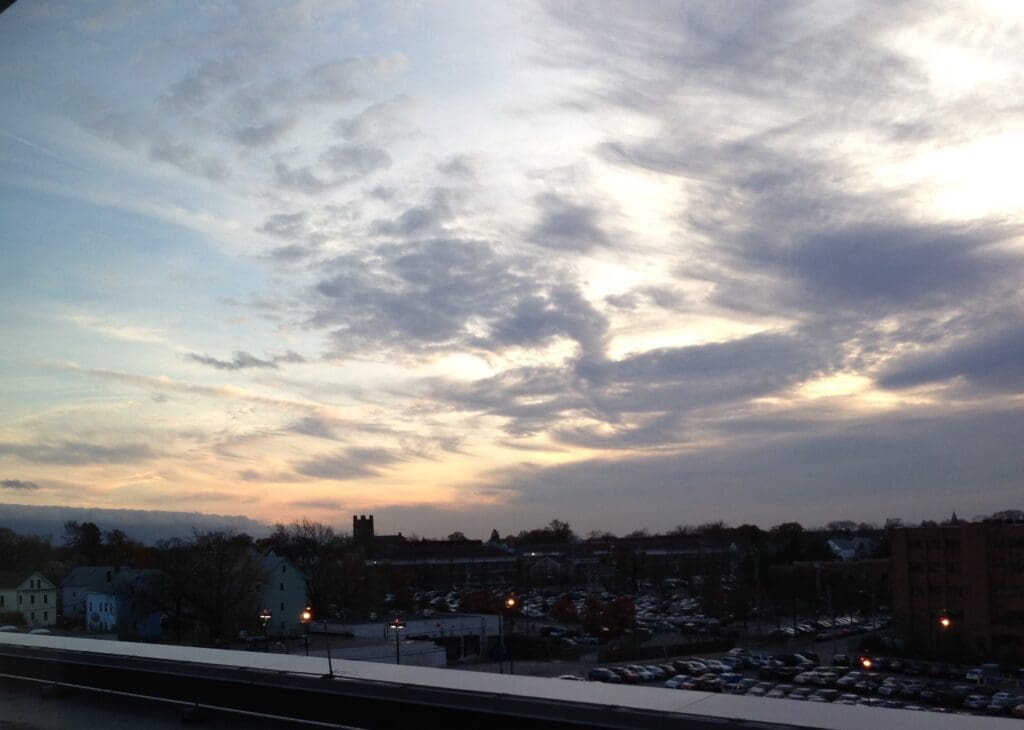 A cloudy sky over a parking lot, with homeless individuals in Rhode Island.