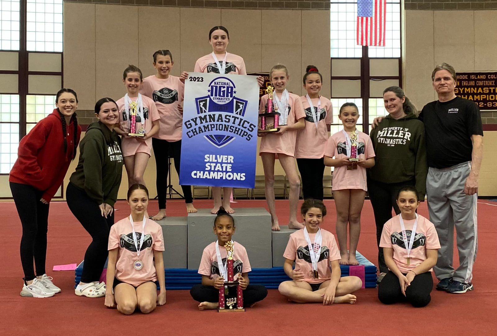 A group of gymnasts posing with their trophies.