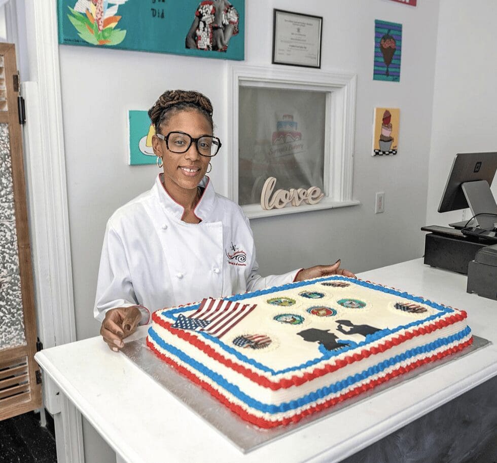 A woman standing in front of a cake.