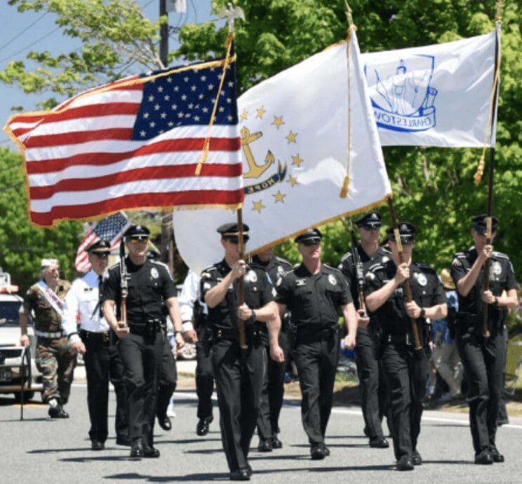 On Memorial Day, a group of police officers march down the street solemnly carrying flags to honor fallen heroes.