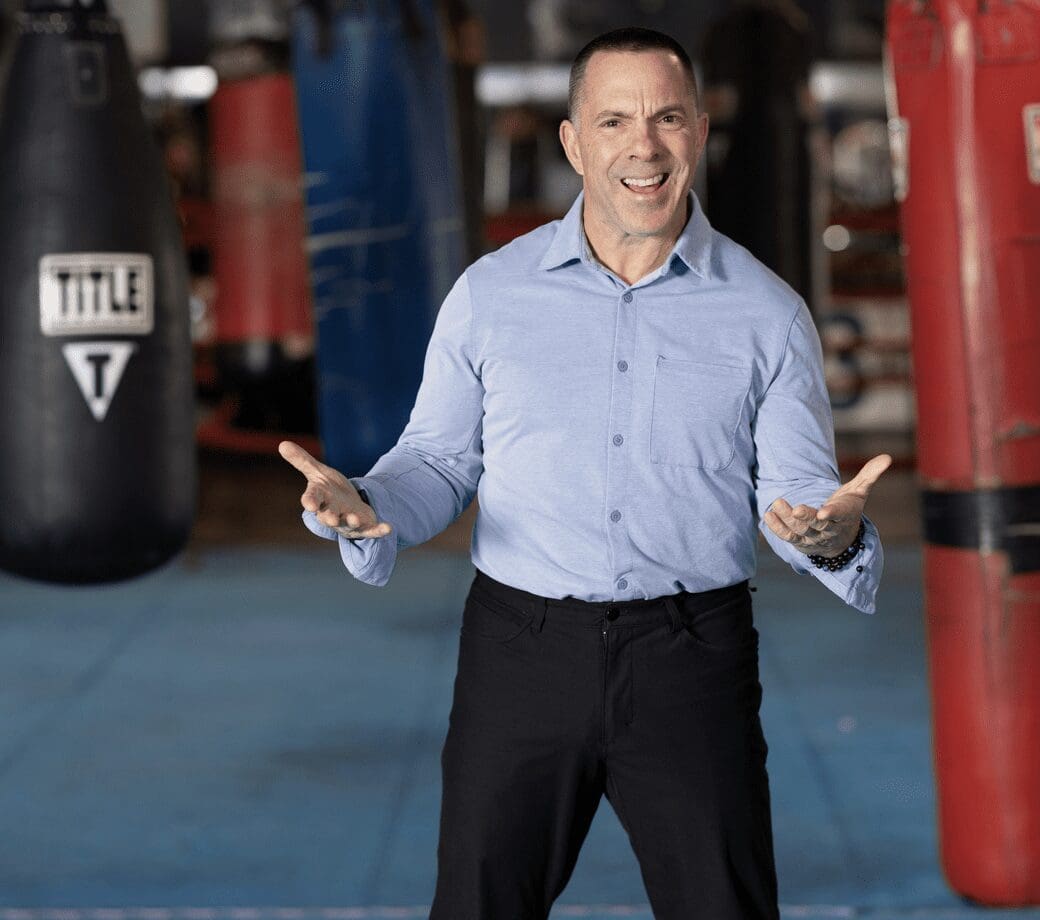 A man standing in front of a boxing ring, demonstrating fitness and exercise techniques in Rhode Island for Burn with Kearns.