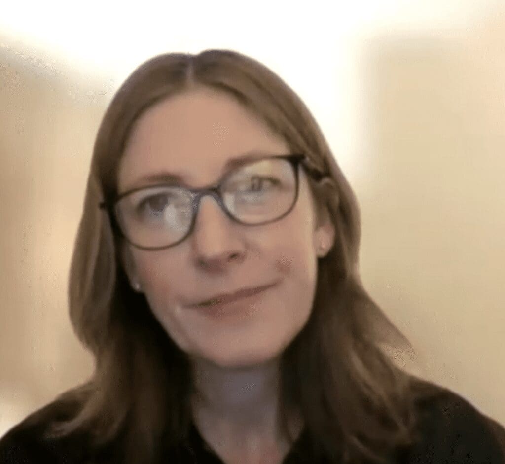 A woman wearing glasses and a black shirt.