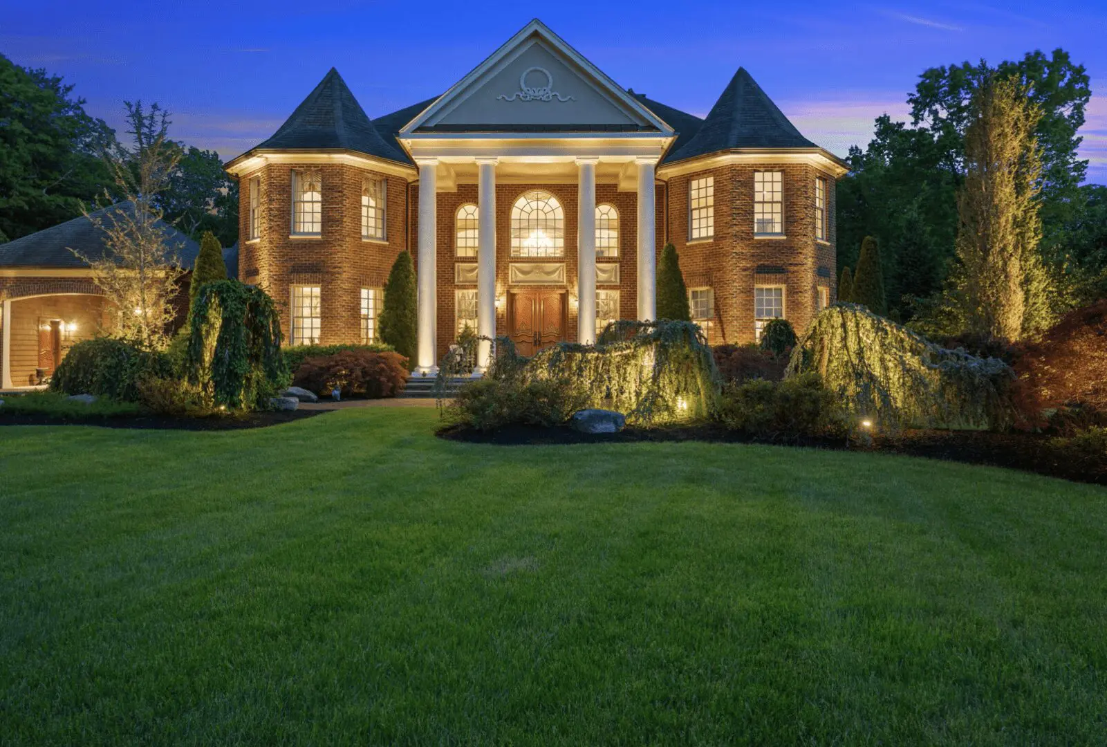 Homes for sale near me, A large brick home at dusk with a large lawn.