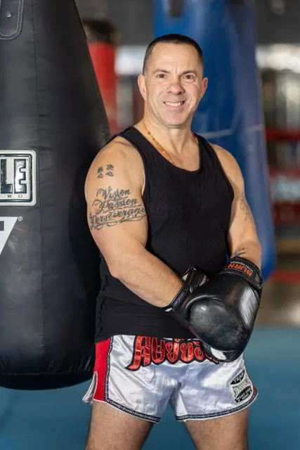 Kevin Kearns posing in front of a boxing bag.