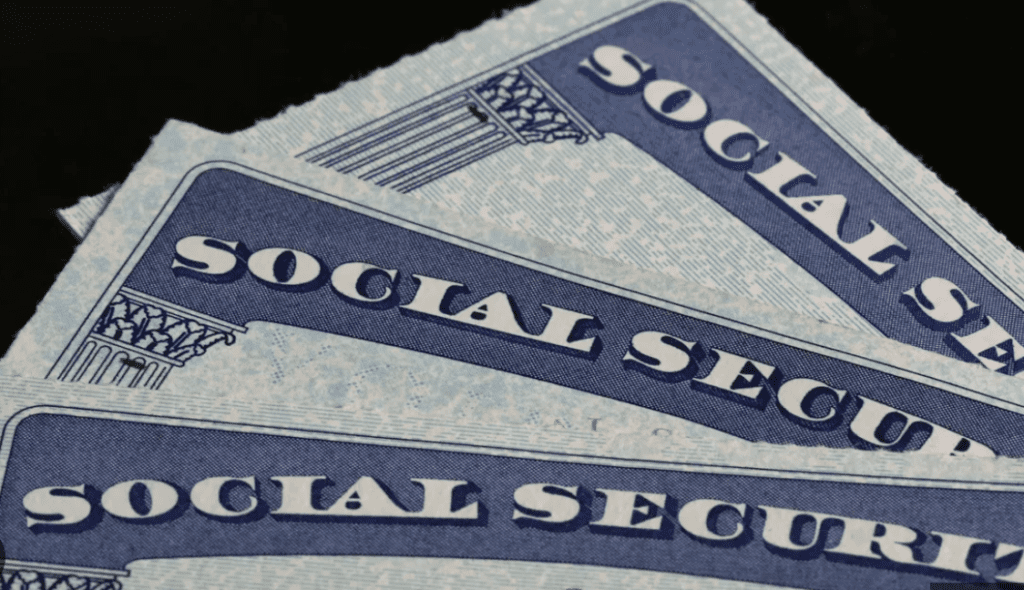 A stack of social security cards on a black background.