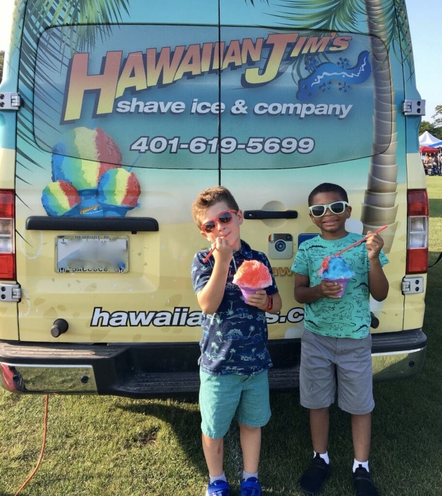 Two boys from the Fresh Air Fund standing in front of a Hawaiian ice truck.