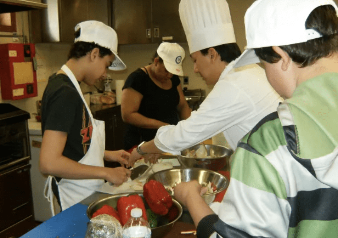 A group of homeless people preparing food in a kitchen in RI.