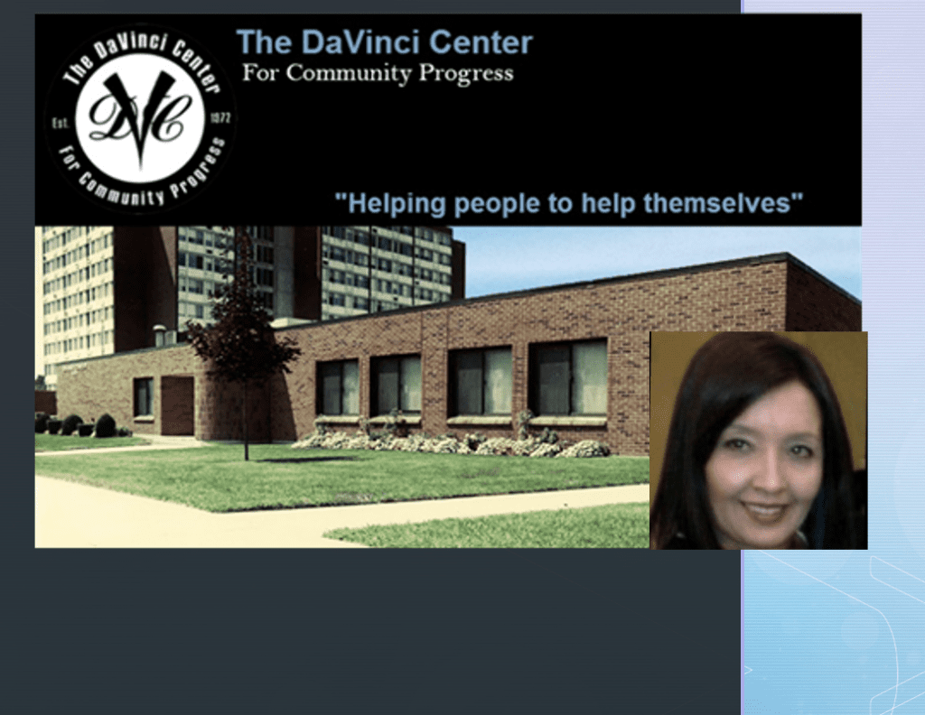 A woman is standing in front of a building with the words the DaVinci Center helping people to help themselves.