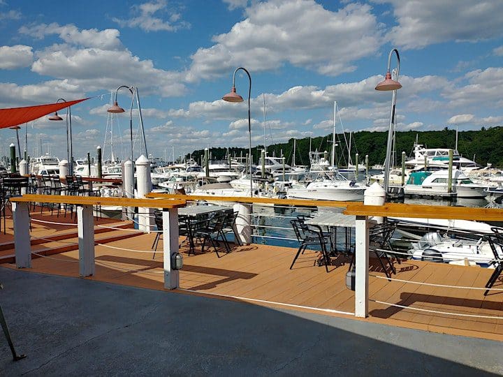 A deck overlooking a marina with boats docked, providing an ideal setting for networking and socializing.
