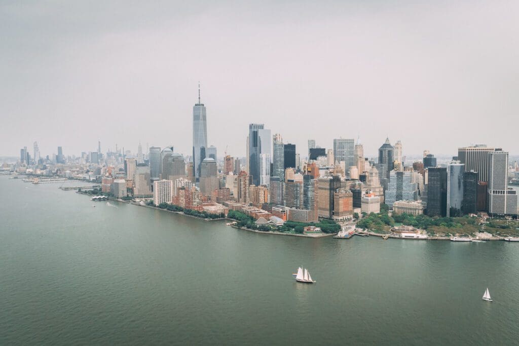 Aerial view of manhattan skyline with sailboats in the water.