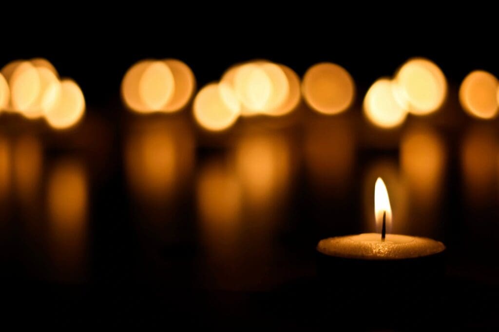 A group of lit candles on a dark background.