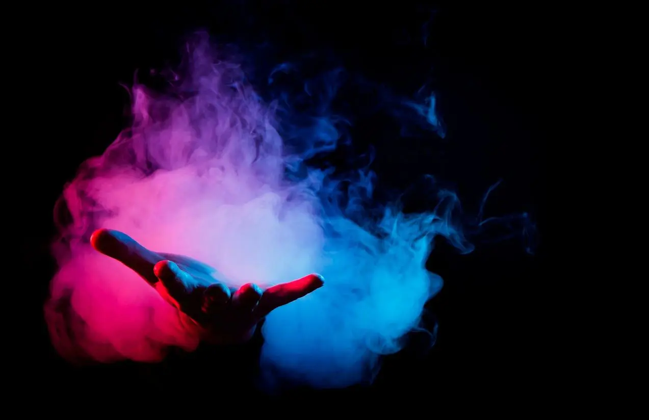A hand with smoke coming out of it on a black background.