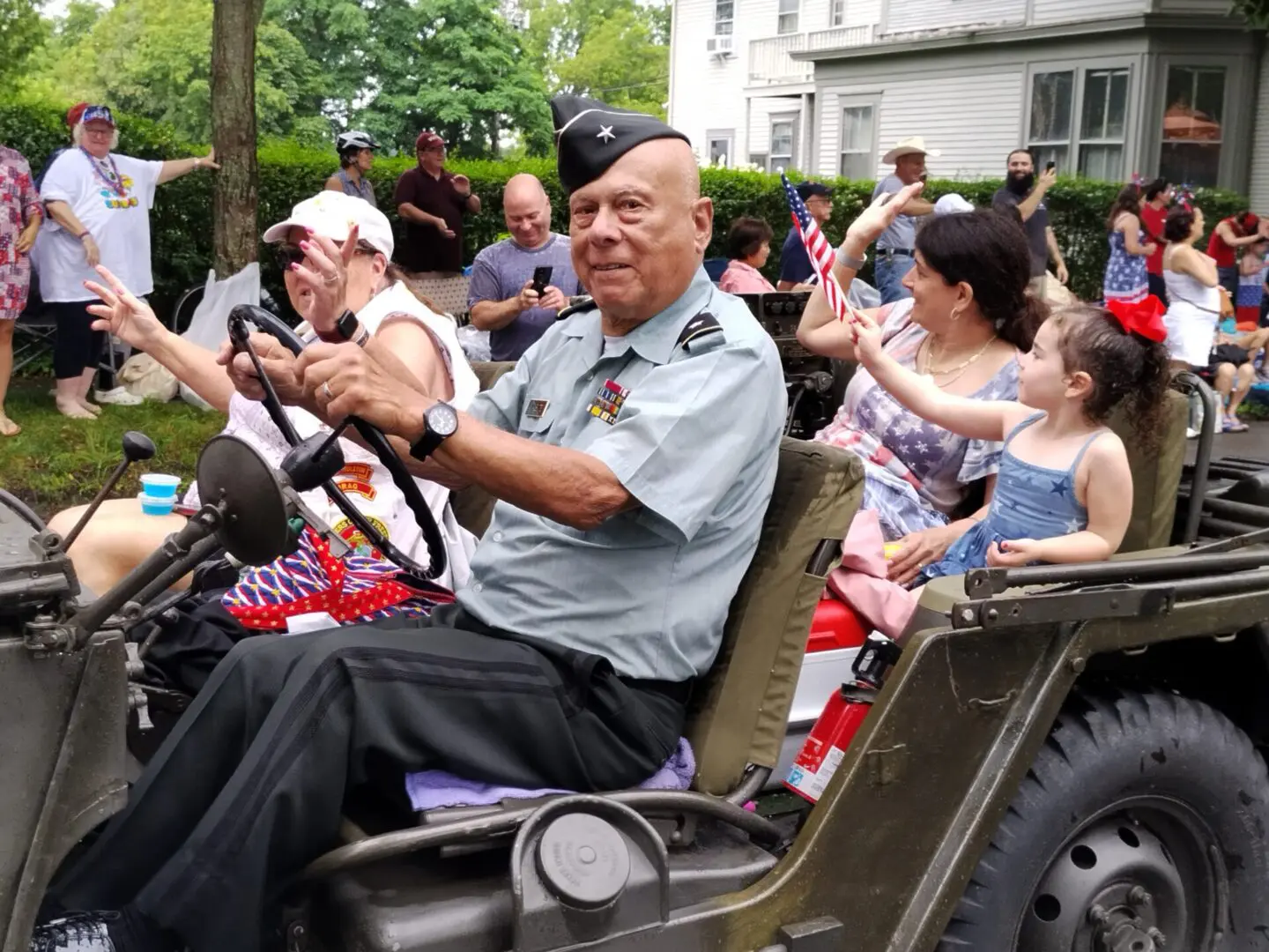A veteran driving a jeep in a parade.