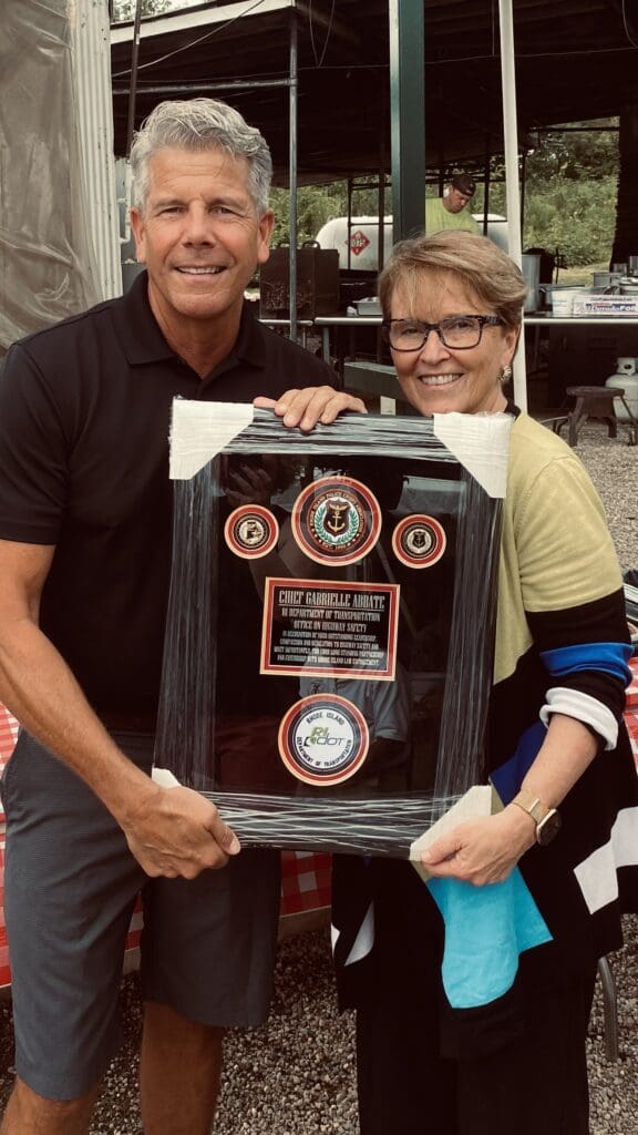 A man and woman holding a framed award.