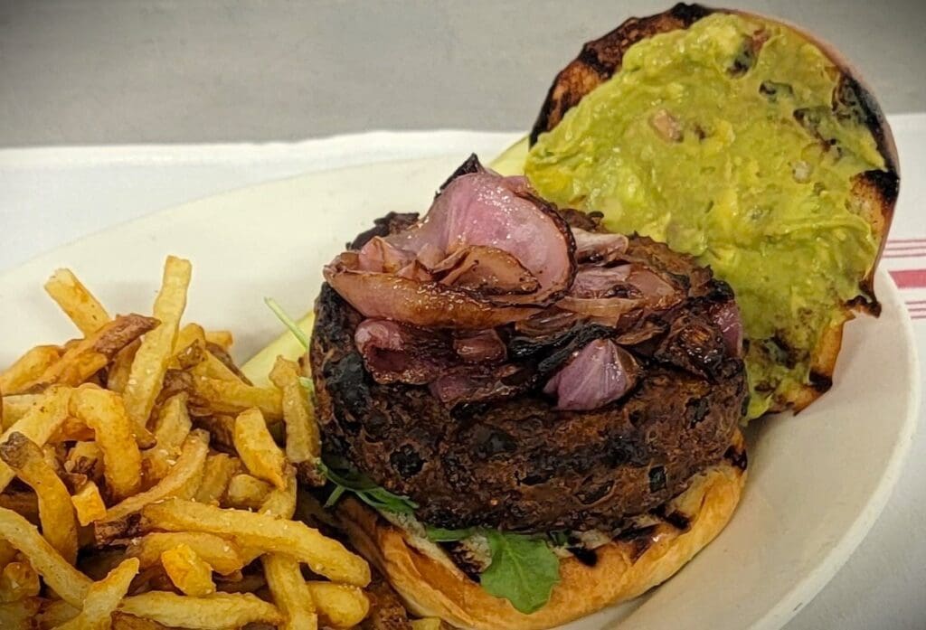 A burger with avocado on a plate recipe.
