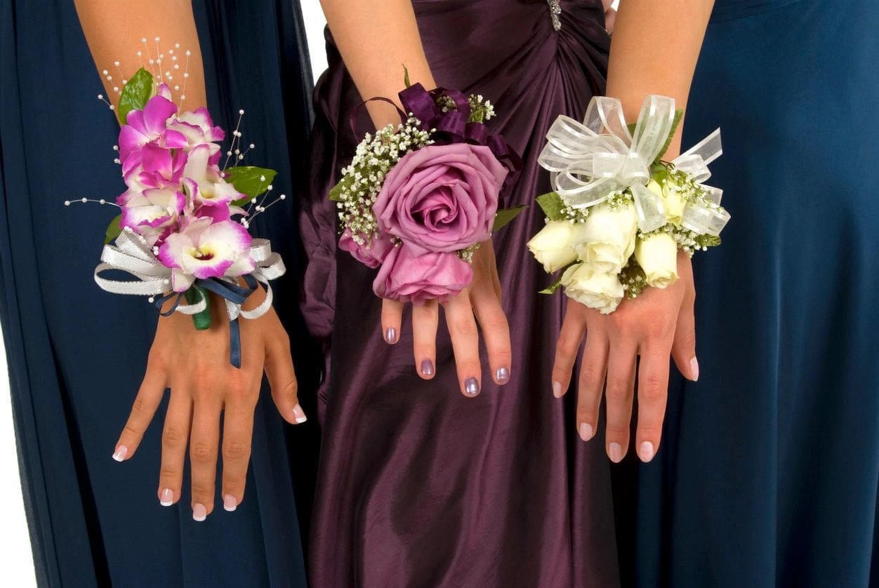 A group of bridesmaids wearing flowers on their wrists.