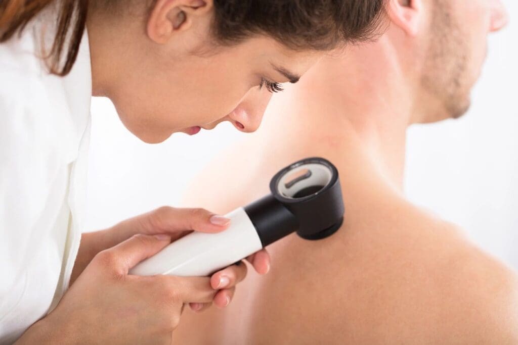 A woman is using an electric device on a man's back.