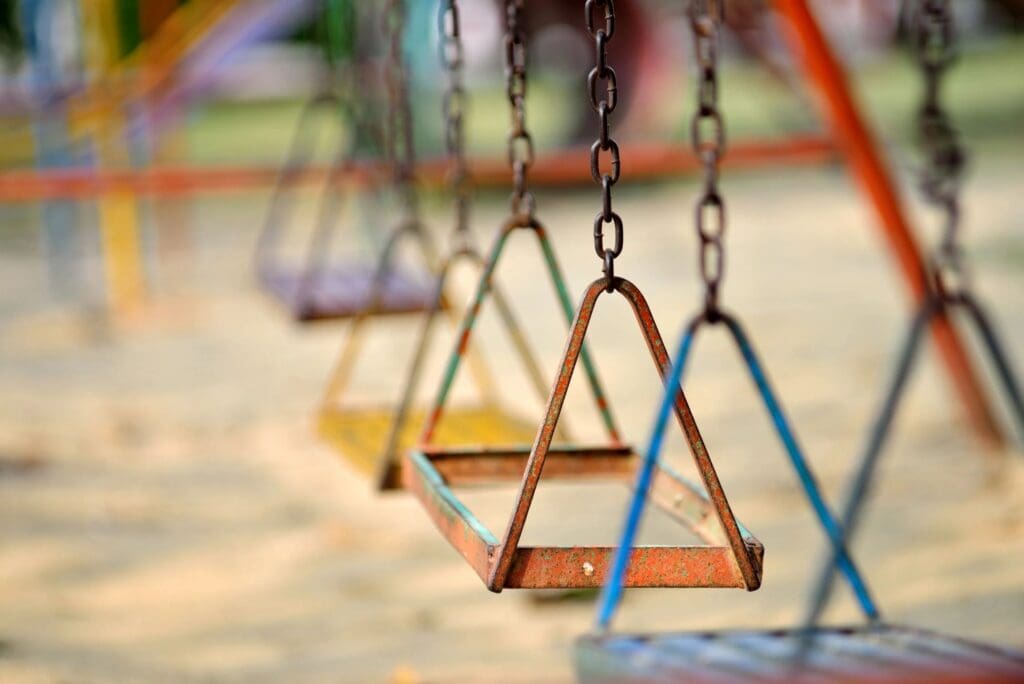 A group of colorful swings in a playground.